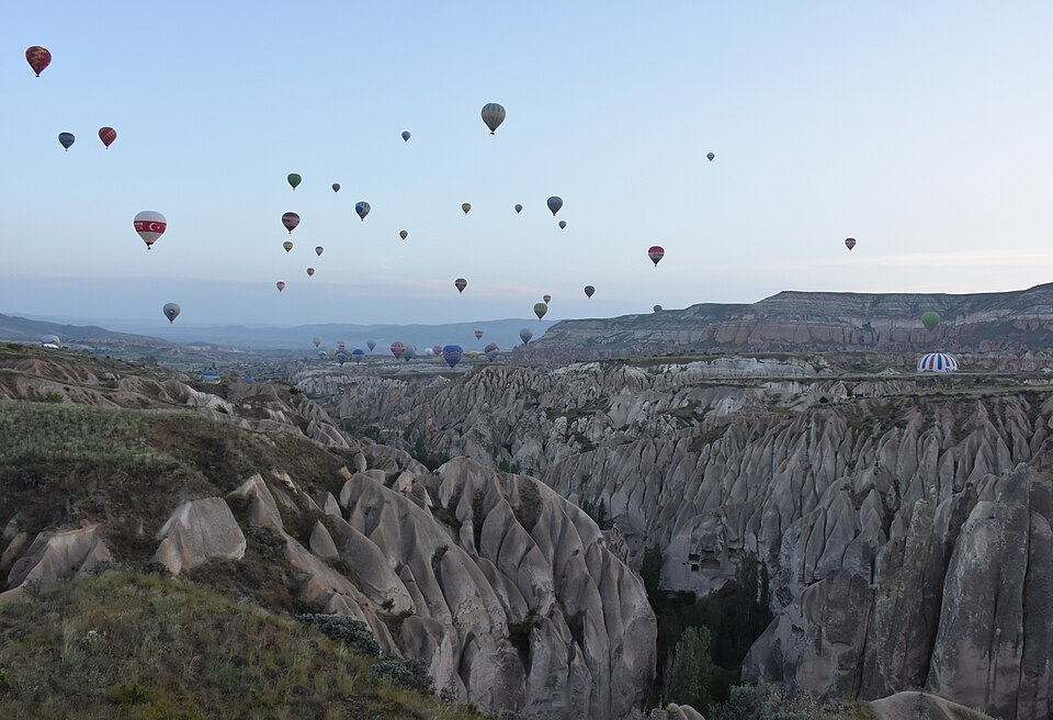Gün doğumunda Kapadokya peribacaları üzerinde uçan sıcak hava balonları
